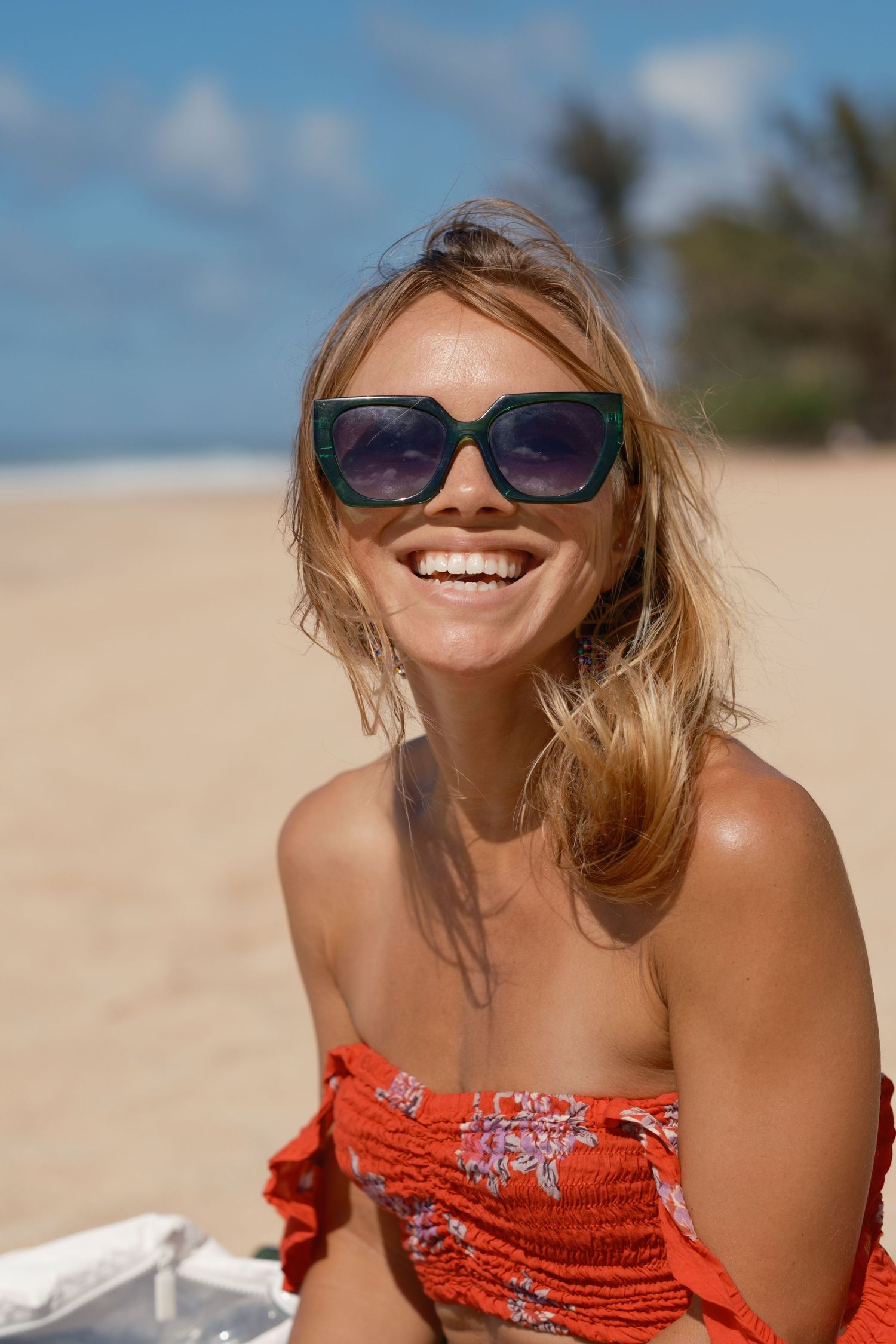 Person in orange beachwear enjoying a sunny day on tropical sand.
