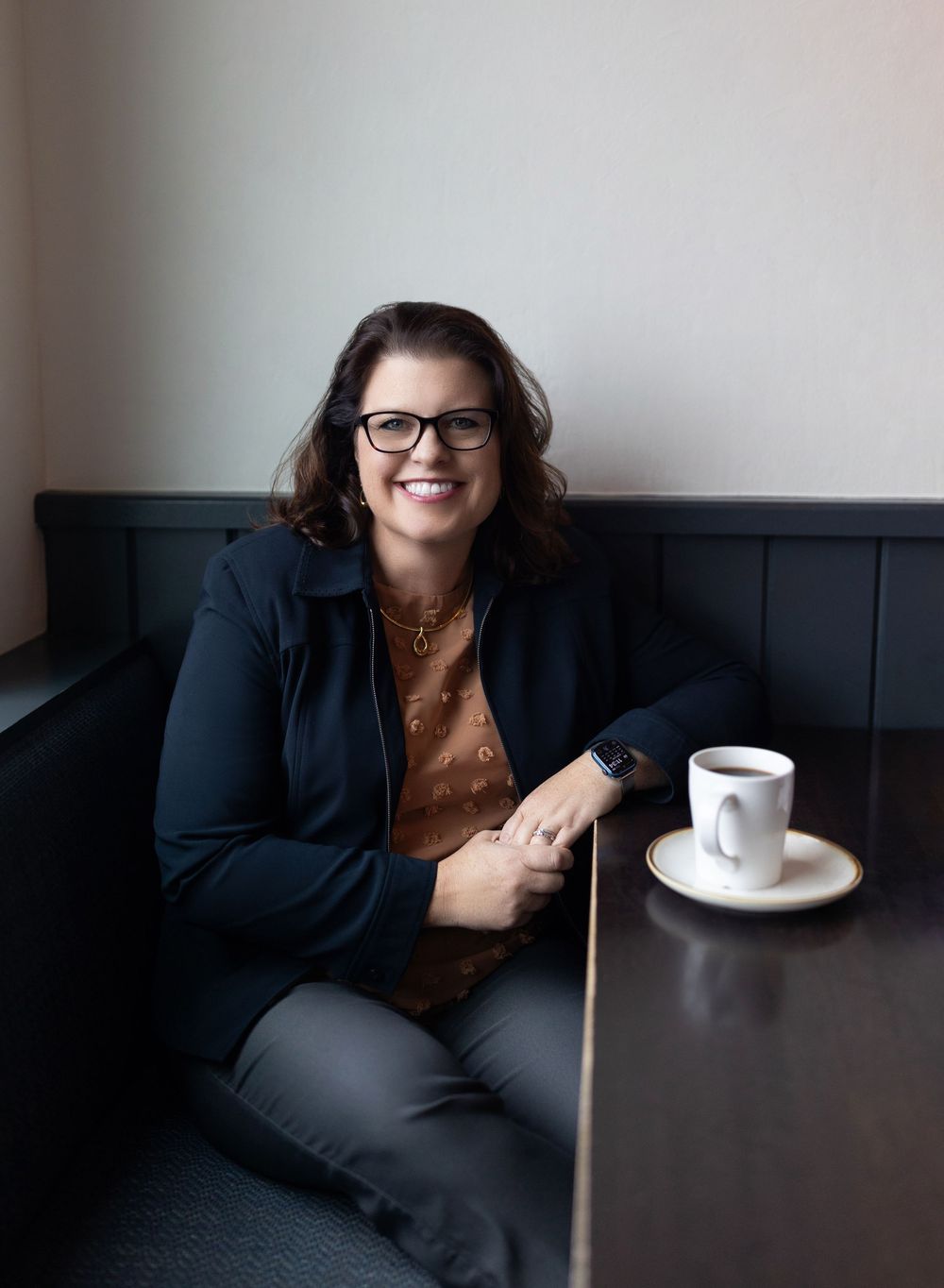 A sequence of photos shows a person in a dark blazer sitting at a table with coffee and engaging in casual conversation.