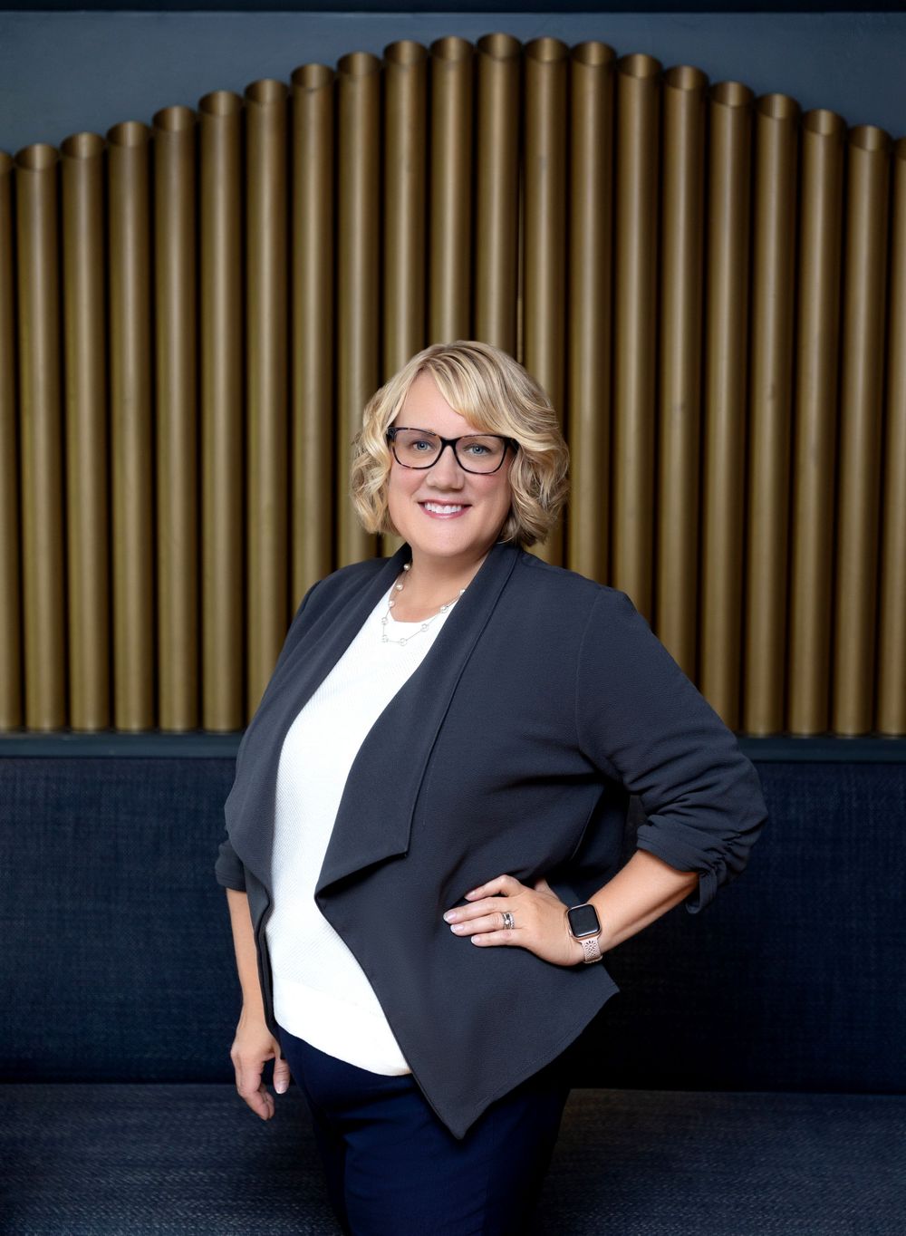 Professional portrait series showing a person in a black blazer and white top posing against a dark background.