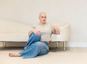 A person wearing denim clothing lies on a white floor in a minimalist setting, shown in a series of artistic poses.