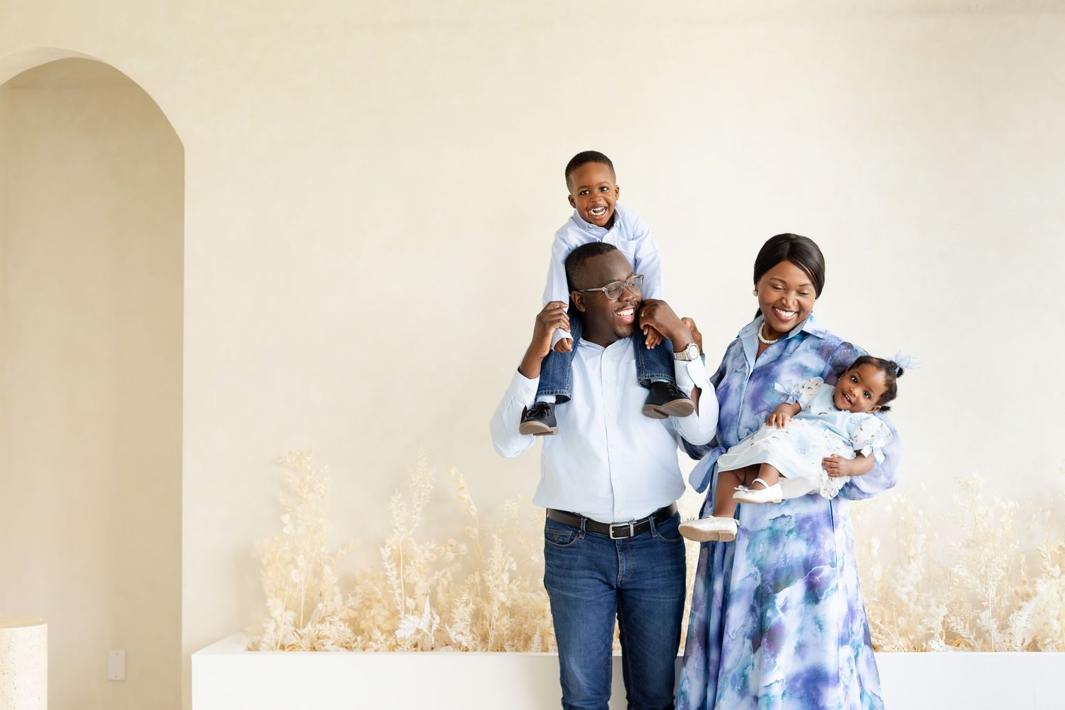 A family wearing coordinating blue and white outfits poses together for a series of candid lifestyle photos.