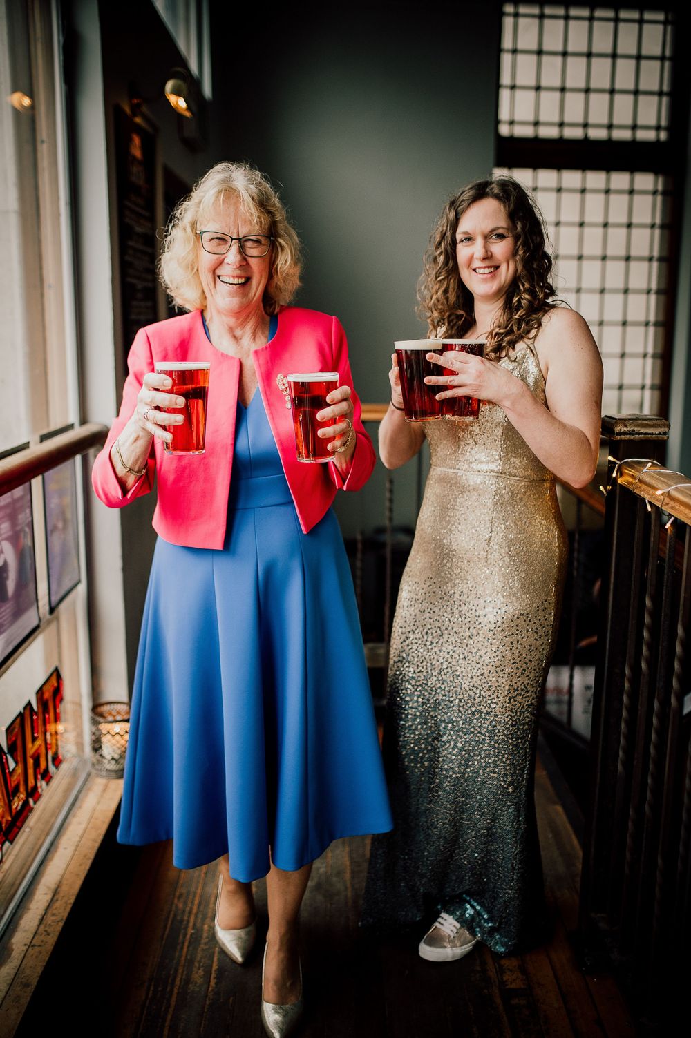 A photo series showing two people in contrasting outfits - a blue dress and sparkly gold gown - sharing drinks and laughter.