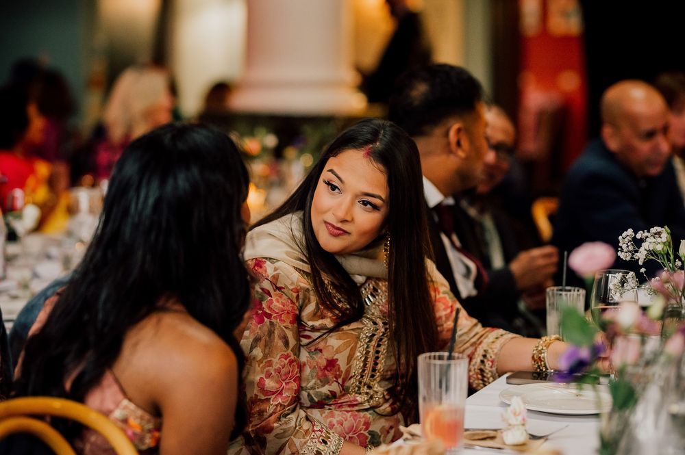 A group of people enjoying a social gathering at a restaurant with colorful decorations and ambient lighting.