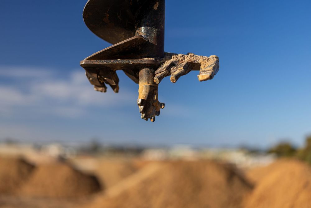 Close-up of auger attachment with dirt – excavator detail shot