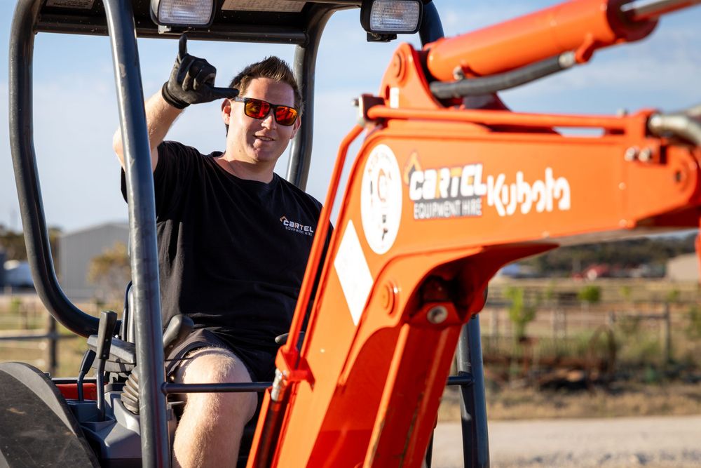 Operator driving Cartel Equipment Hire excavator on job site