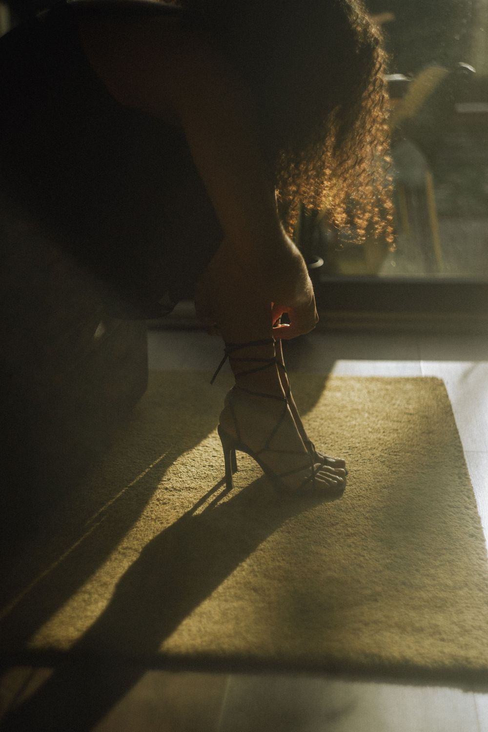 Artistic shadow play on a beige carpet with dramatic lighting creating long dark shapes.