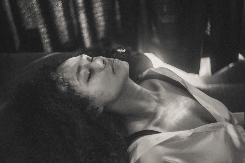 Moody black and white portrait series showing contemplative expressions in dim lighting.