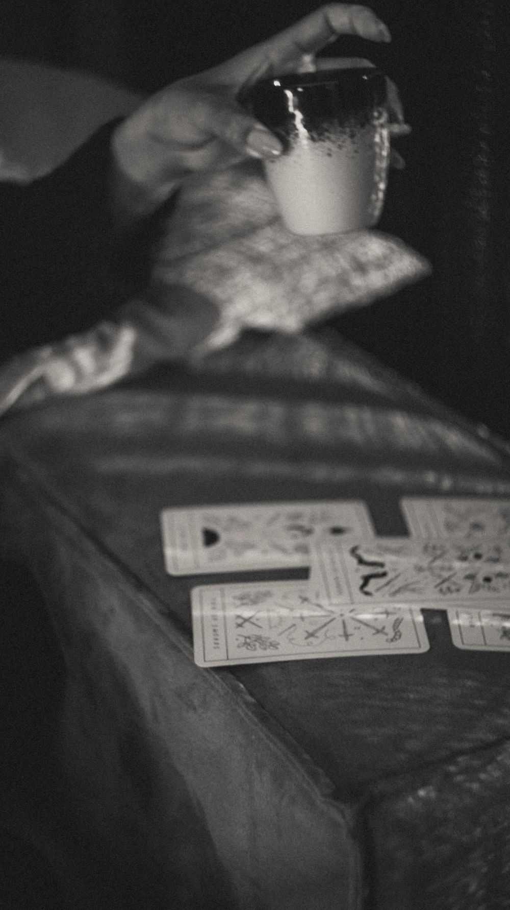 Close-up view of playing cards laid out on dark wooden table surface.