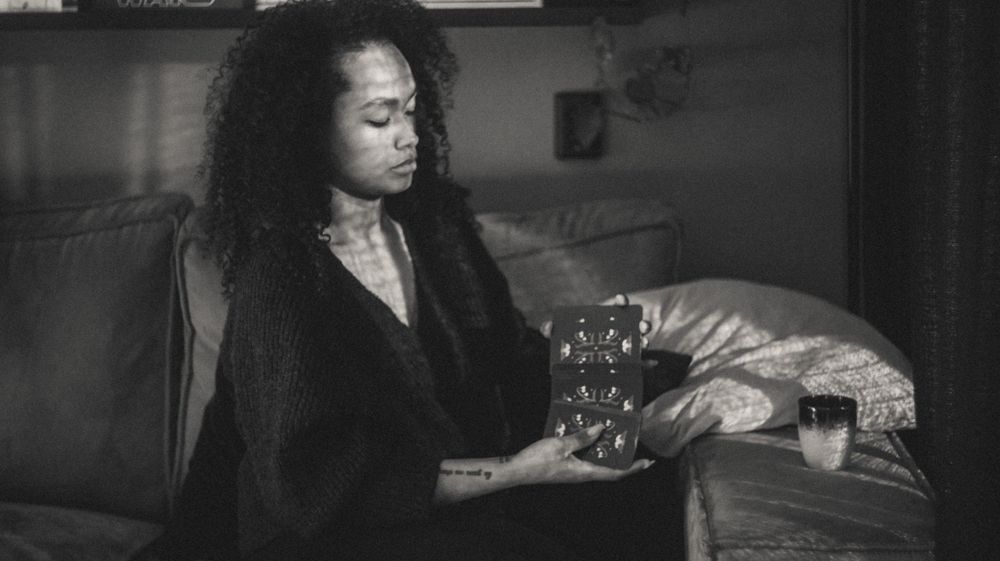 Person with curly hair reclining while looking at something off-camera.