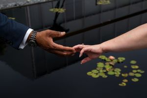 Close-up shot of hands exchanging wedding rings during an intimate ceremony.