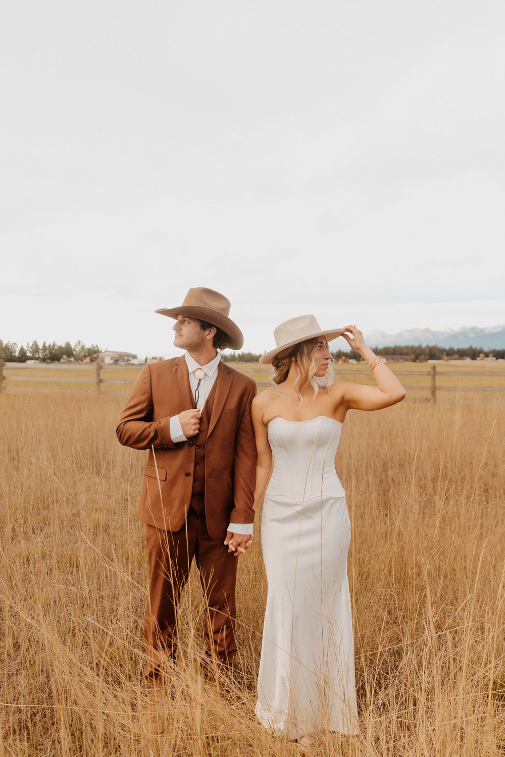 A couple in formal attire poses romantically in a golden wheat field during sunset in Kalispell, Montana.
