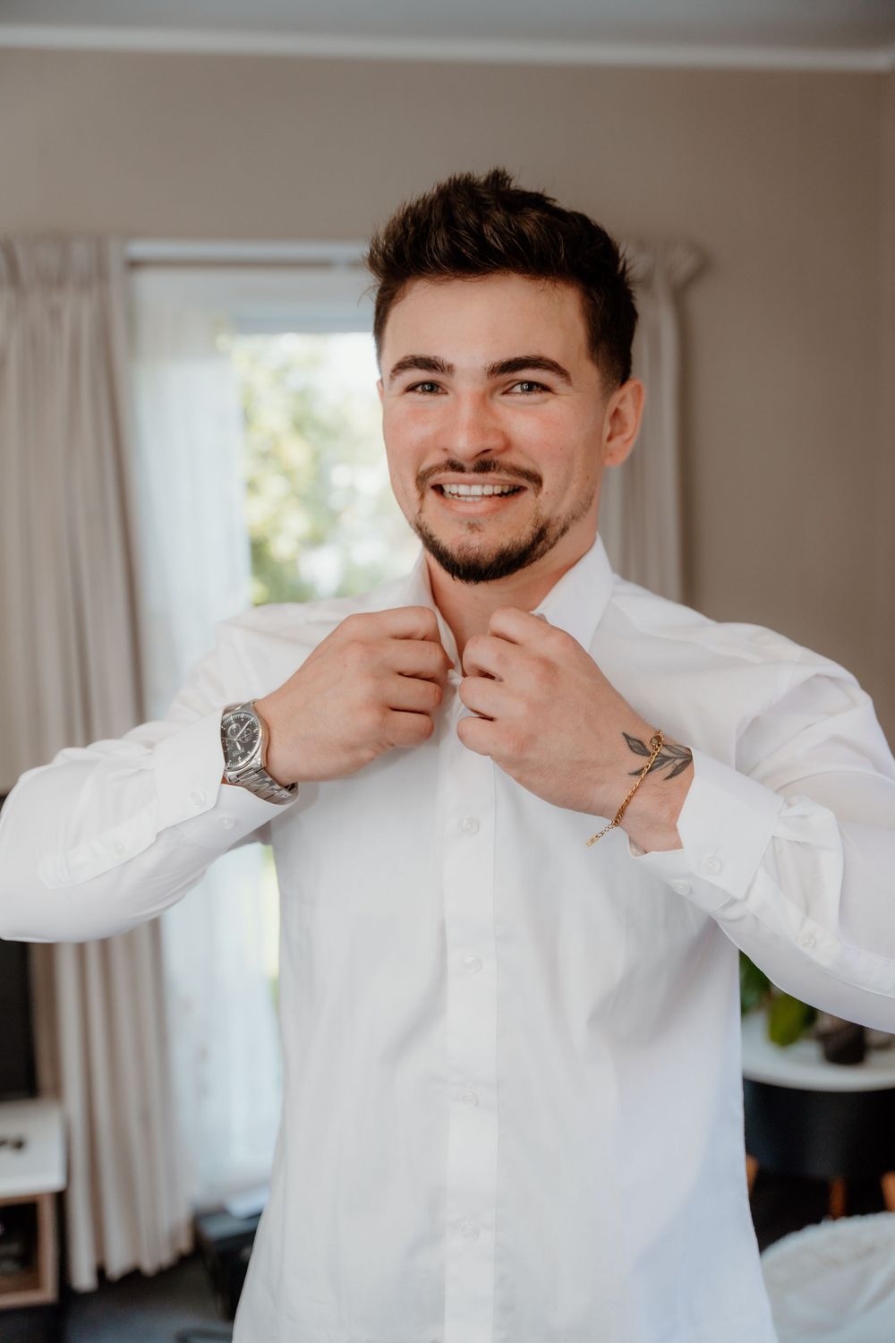 Formal wedding preparation with white dress shirt and wrist watch details.