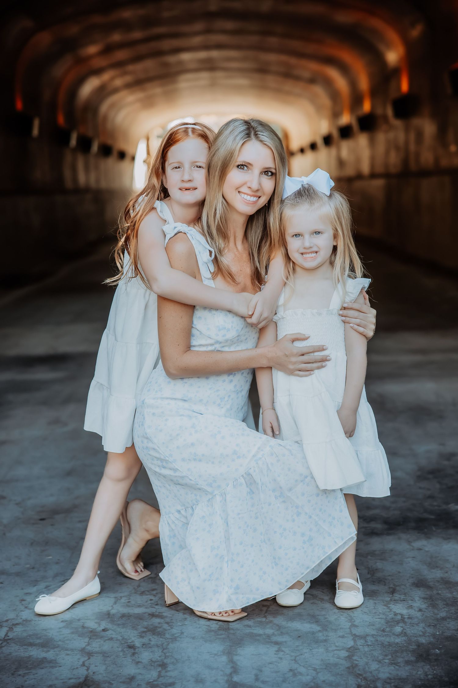 A family portrait captured in a tunnel with everyone wearing coordinated white outfits.