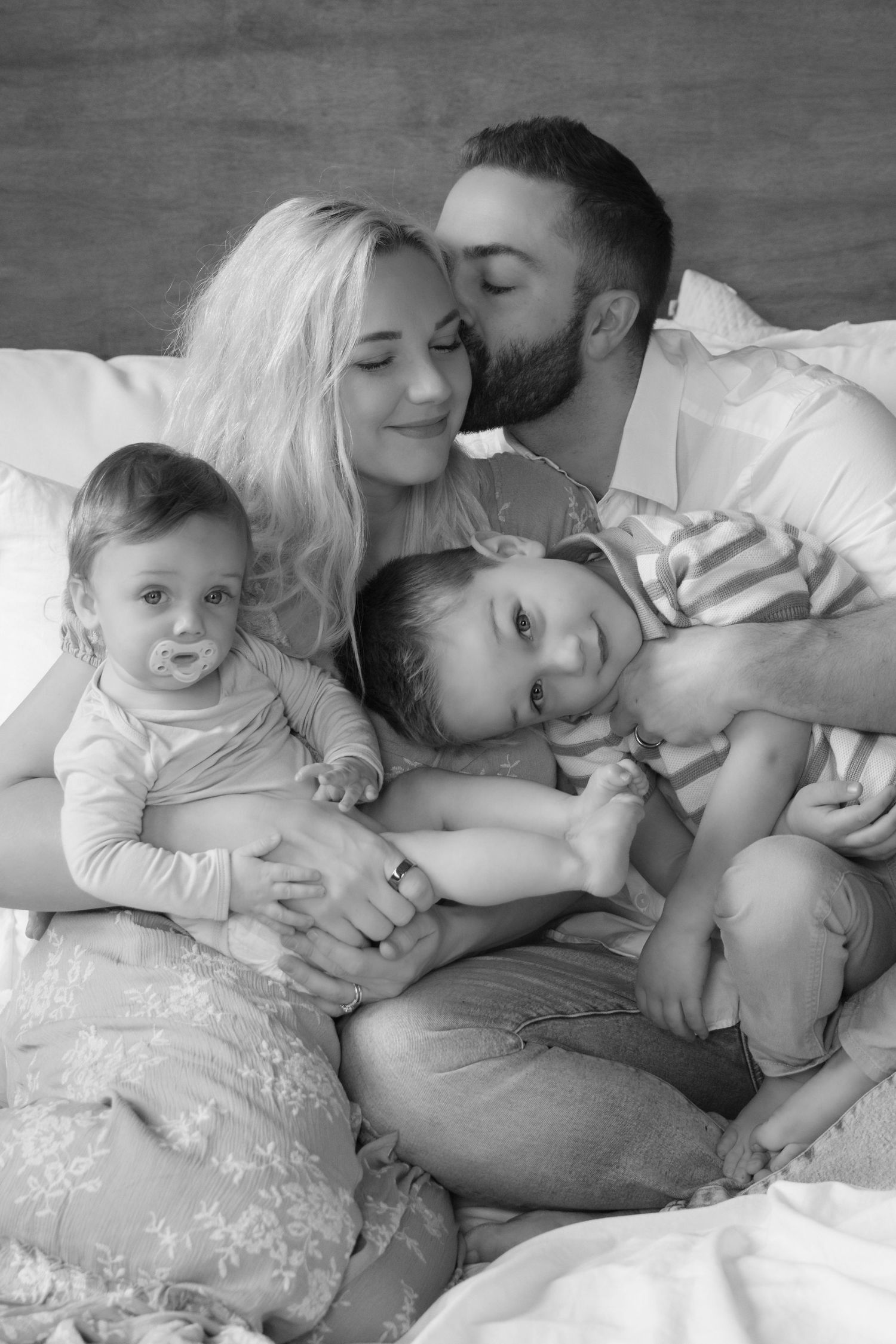 family of four snuggling on a bed during in studio family session in Stillwater, Minnesota