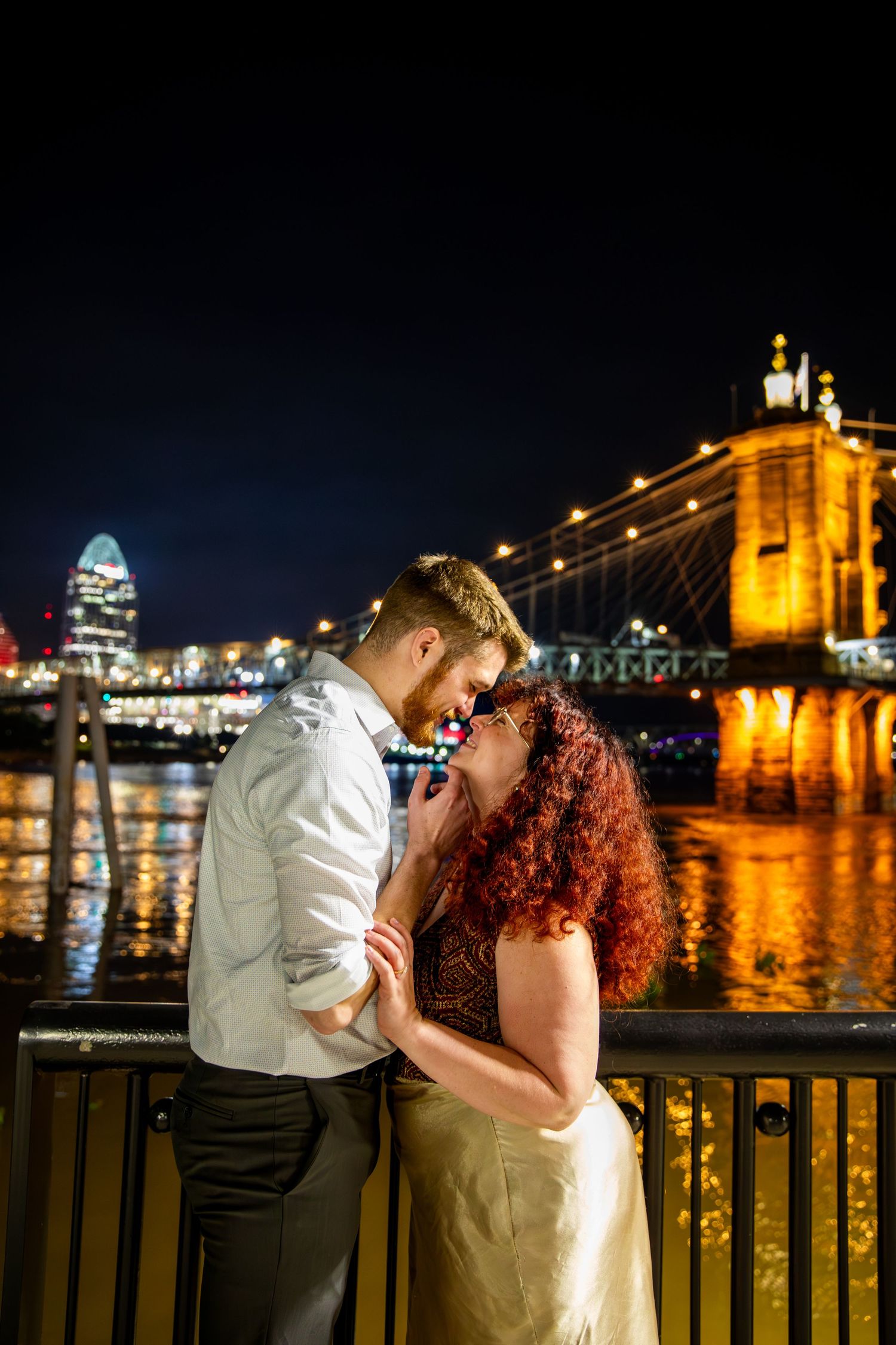 Couple sharing a surprise proposal in Covington, Kentucky with romantic riverside scenery, candid engagement photography moment
