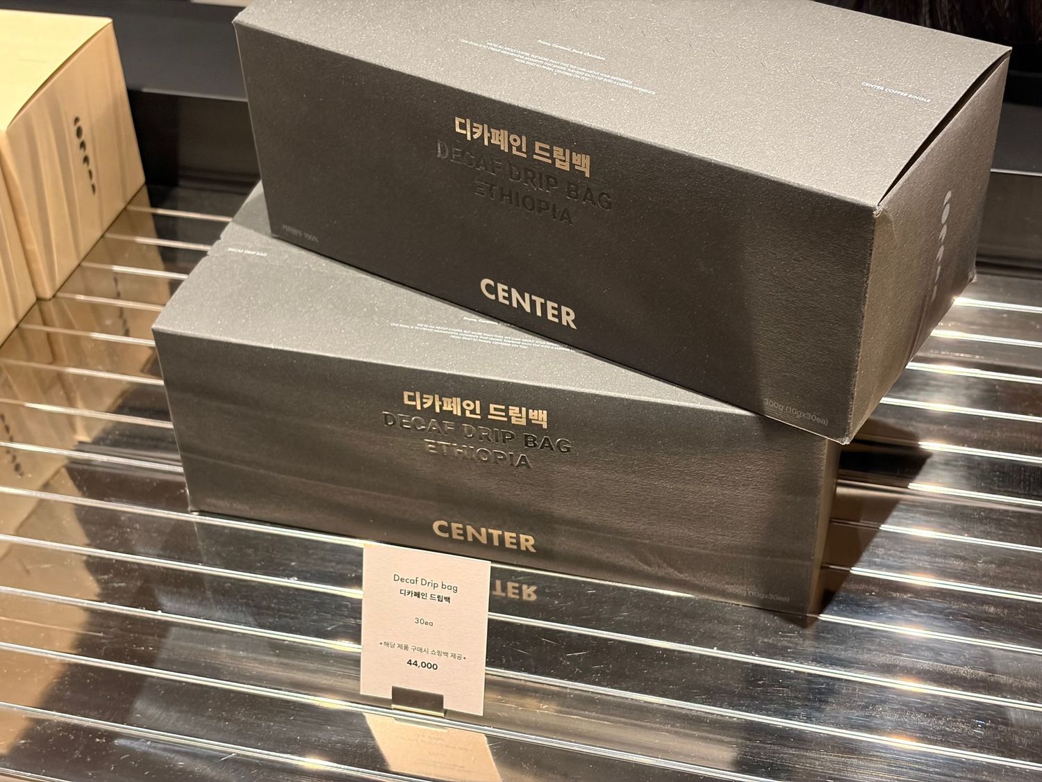 Two dark gray Korean gift boxes labeled CENTER stacked on a retail shelf display.