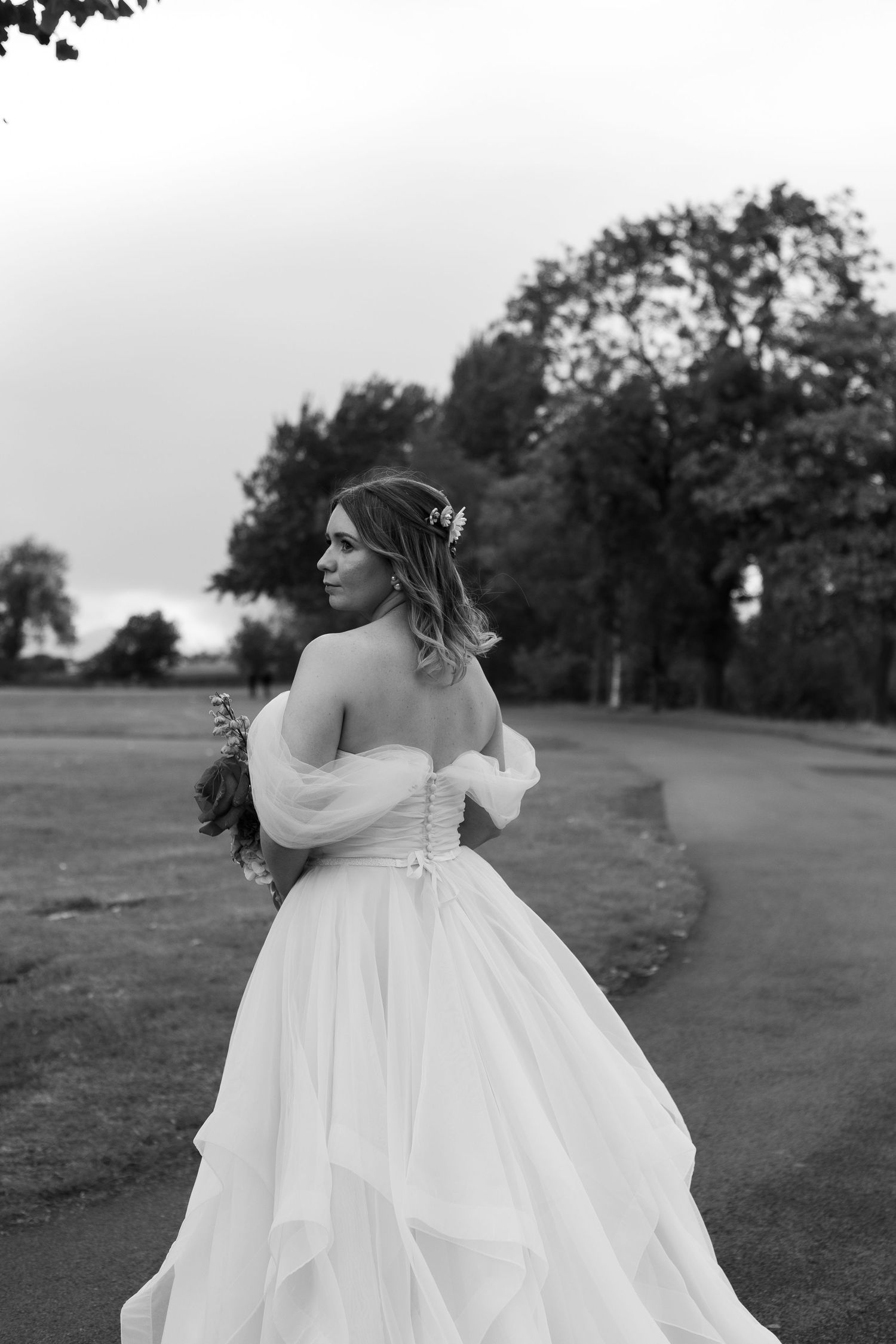 bride posing with her head over her shoulder showcasing the back of her dress at waylay brewery venue in Newcastle.