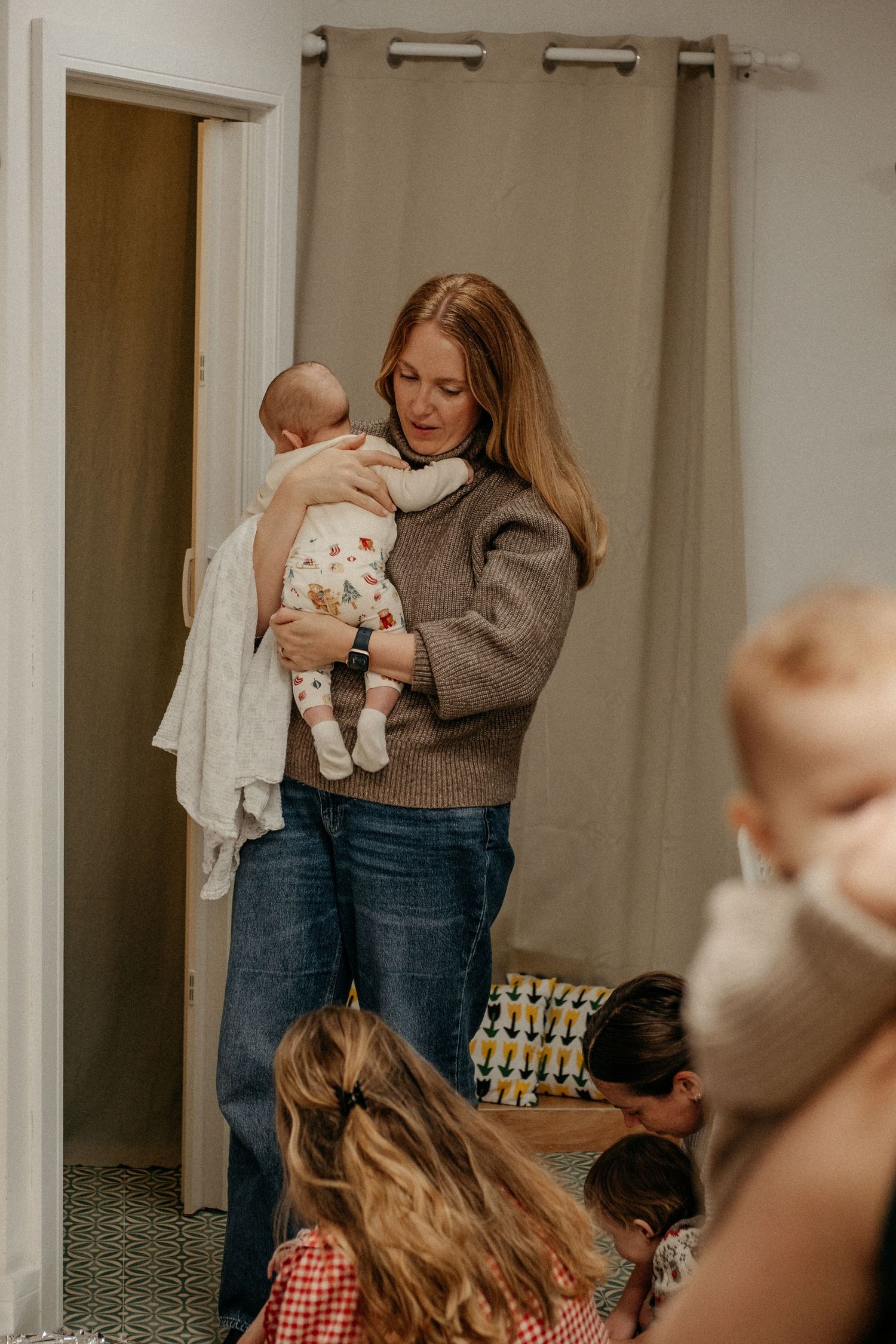 Mom cuddling newborn in play cafe in Gosforth