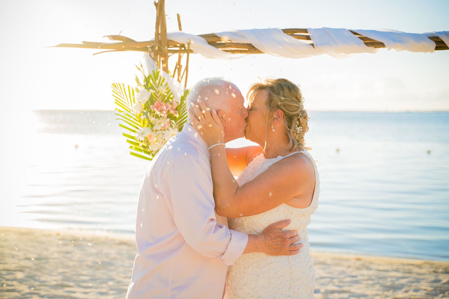 Bride and groom sharing first kiss with confetti at their Mauritius beach wedding
