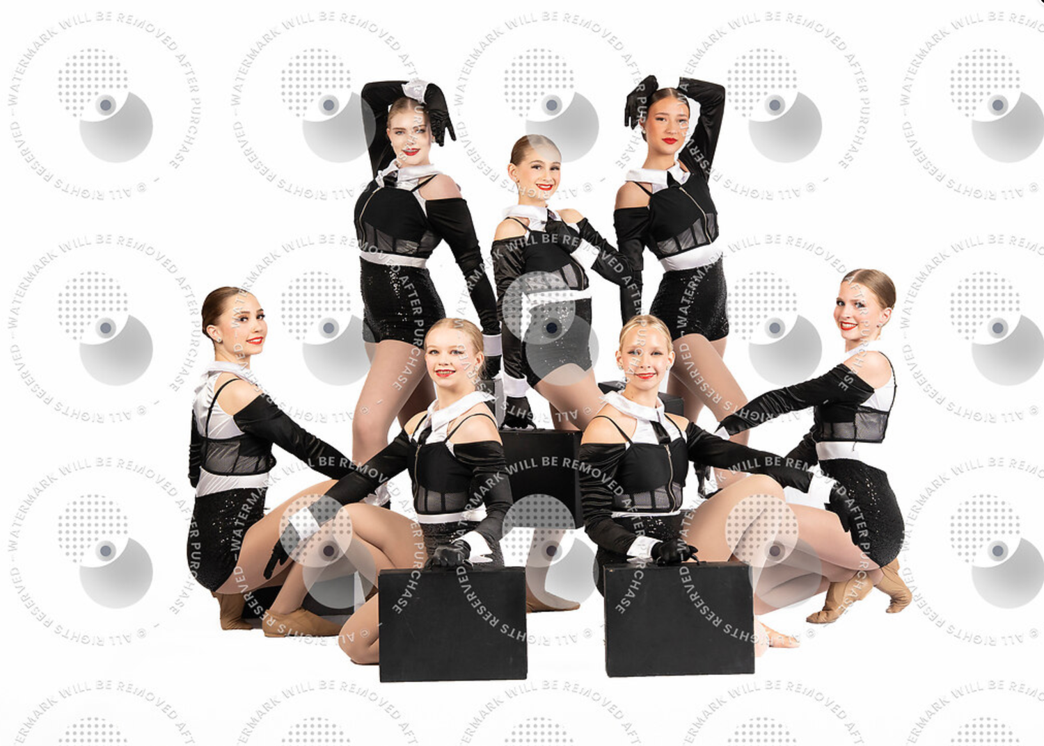 Seven dancers in black costumes pose together for a group dance team portrait photo.