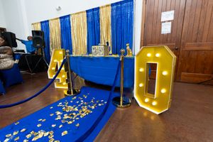 Gold marquee number 40 display with royal blue carpet and gold confetti for a 40th birthday party celebration.