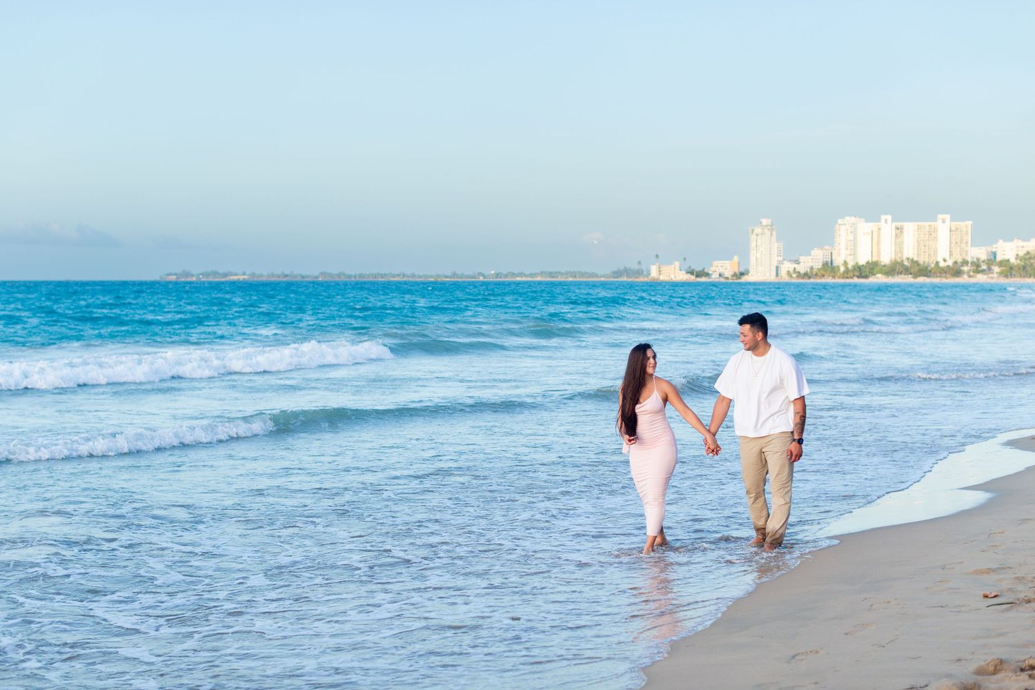 Couples portrait walking along the beach in Isla Verde, Carolina, Puerto Rico.