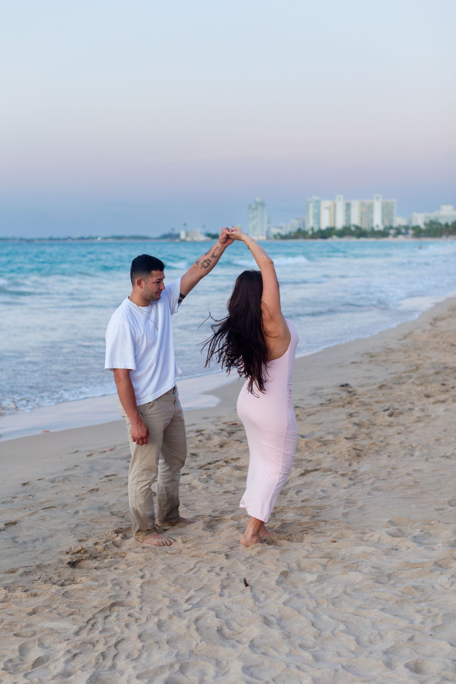 Couples portrait (man twirling woman) at the beach in Isla Verde, Carolina, Puerto Rico.