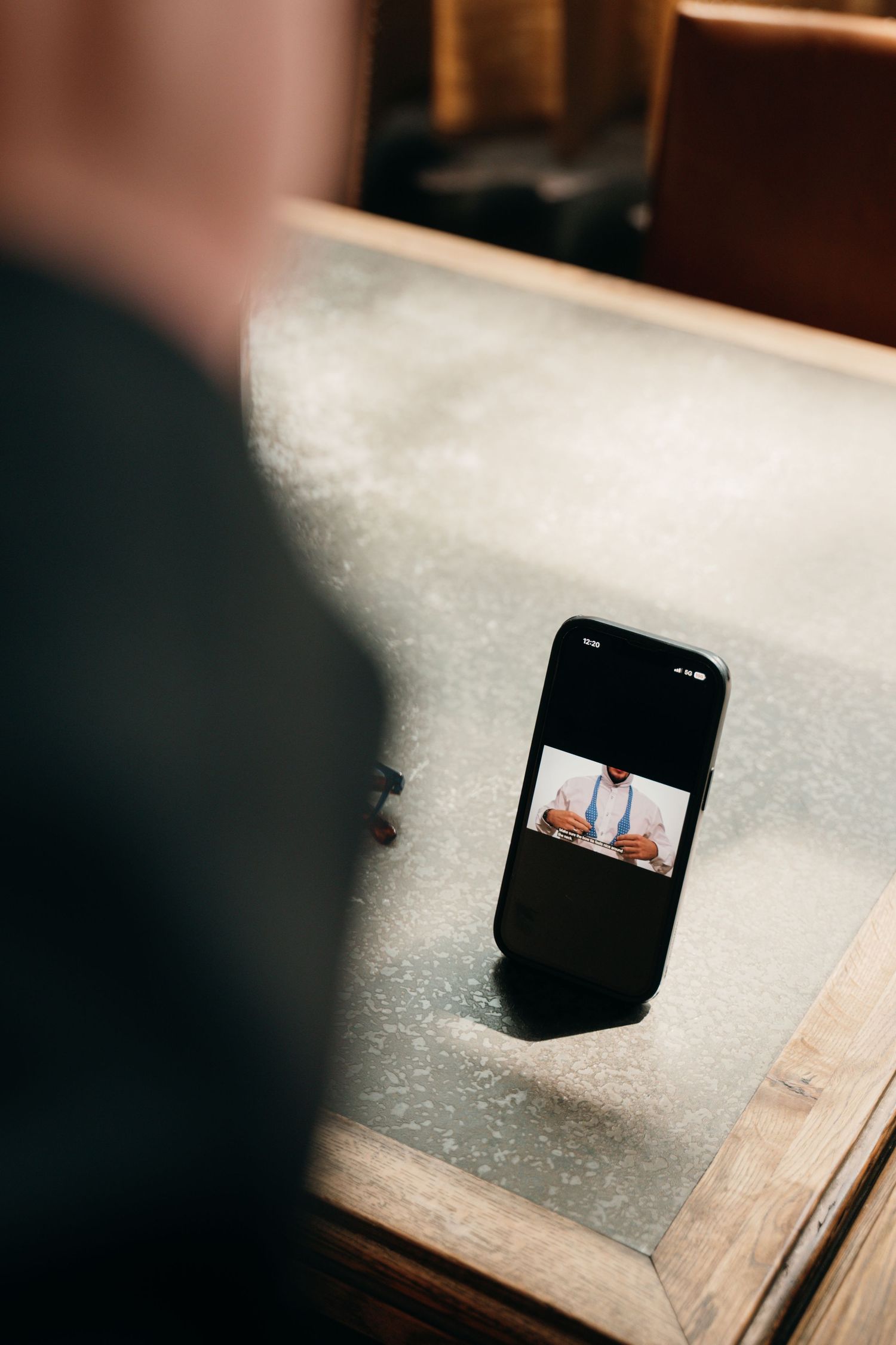 Smartphone displaying a wedding ceremony video resting on a wooden surface in a church.