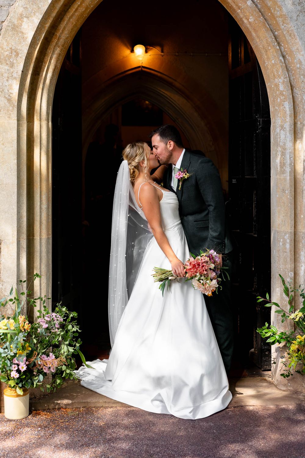 The new Mr and Mrs kiss outside Stoodleigh Church Wedding