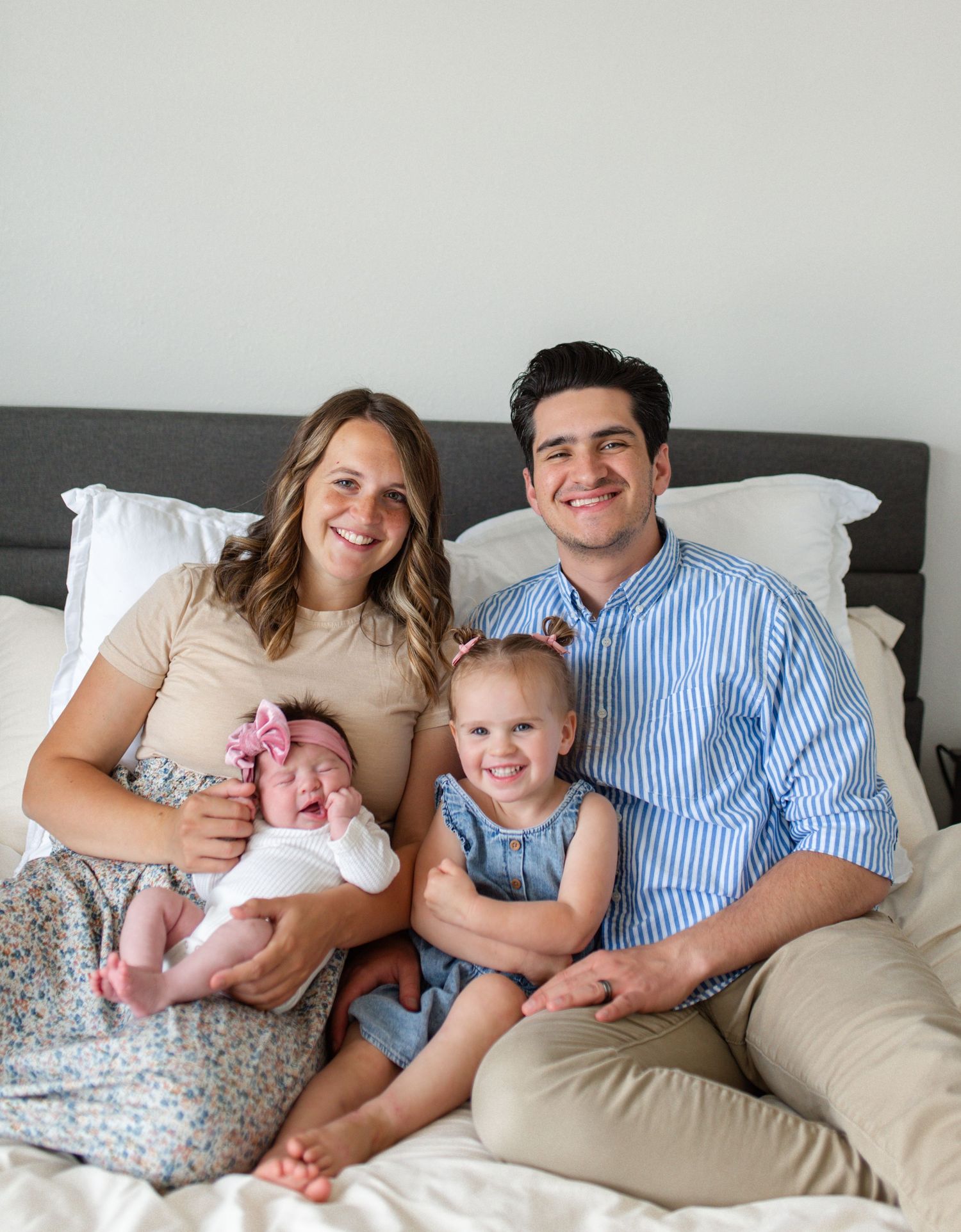 Lifestyle newborn photography in O'Fallon MO showing a family cuddling on the bed