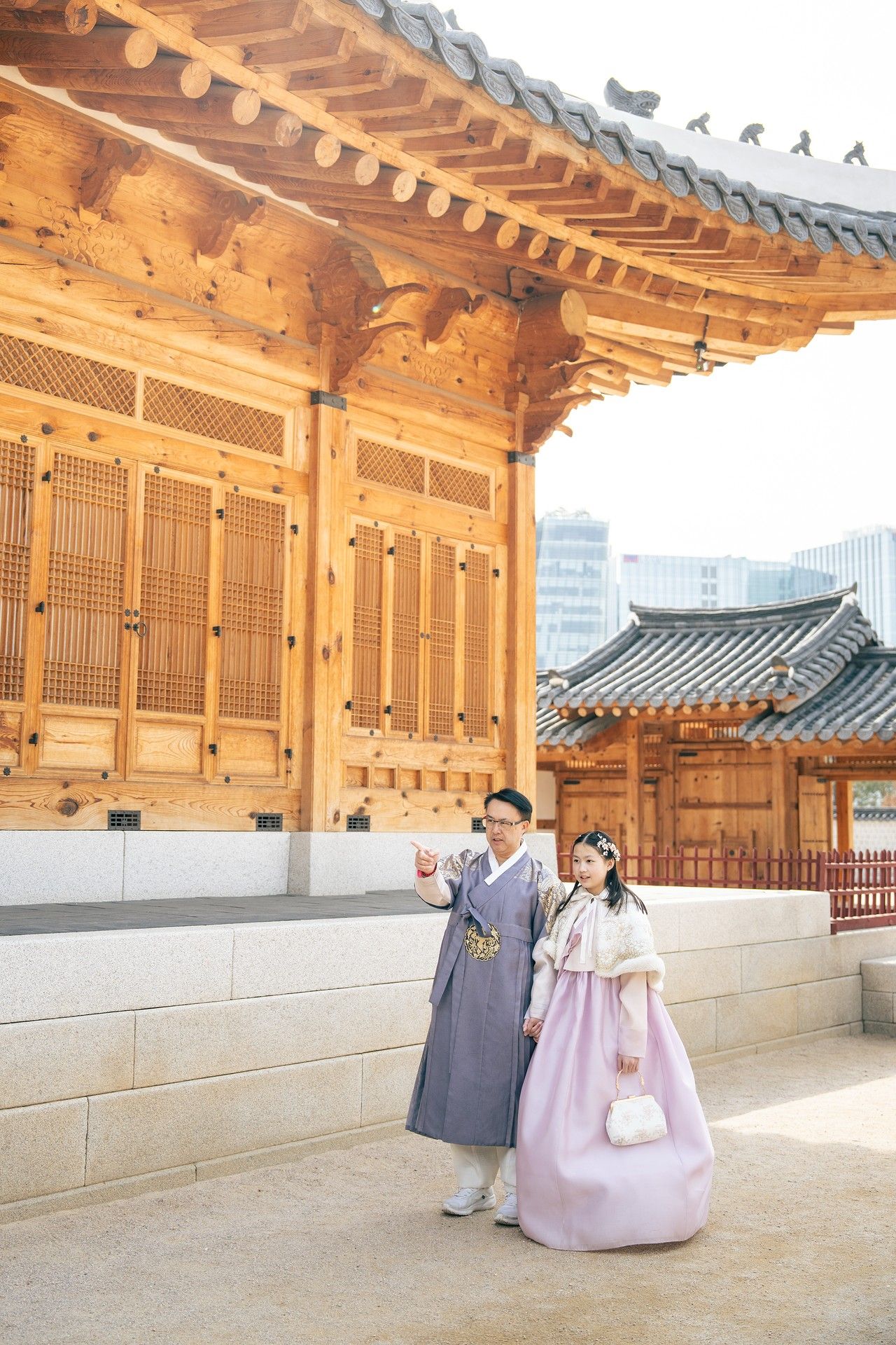 Couple wearing traditional Korean hanbok at a historic palace courtyard in Seoul, South Korea.