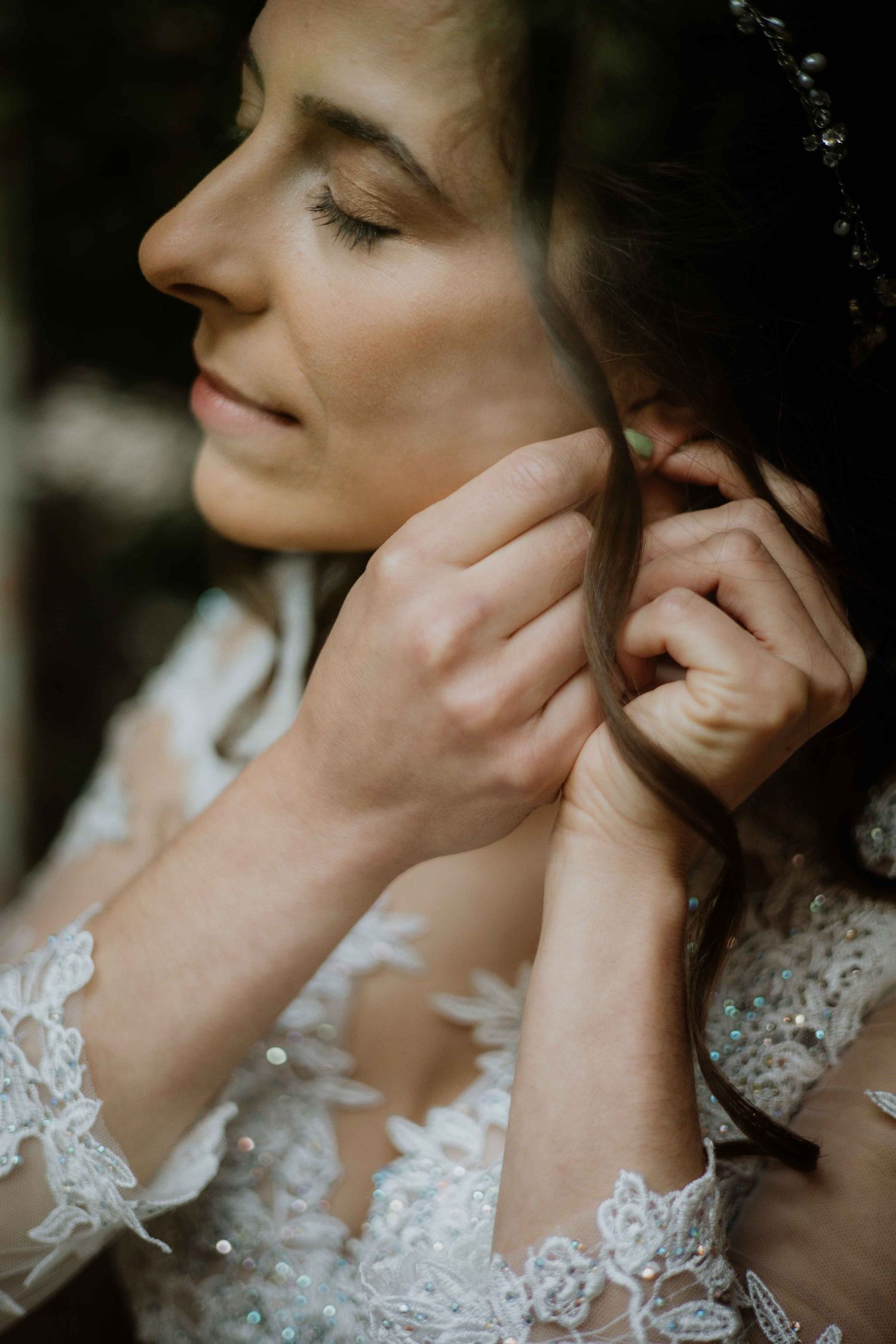 Delicate detail shot of lace wedding dress and jewelry.