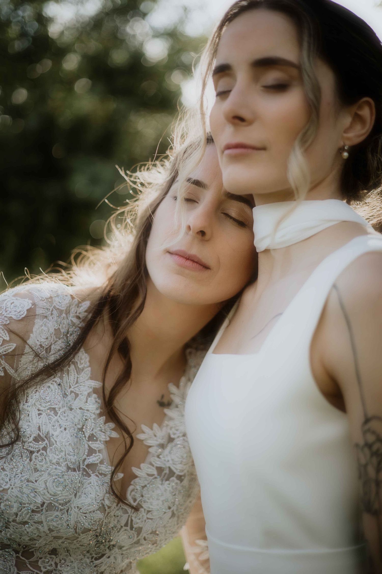 Two people in white lace and formal wear sharing an intimate moment.