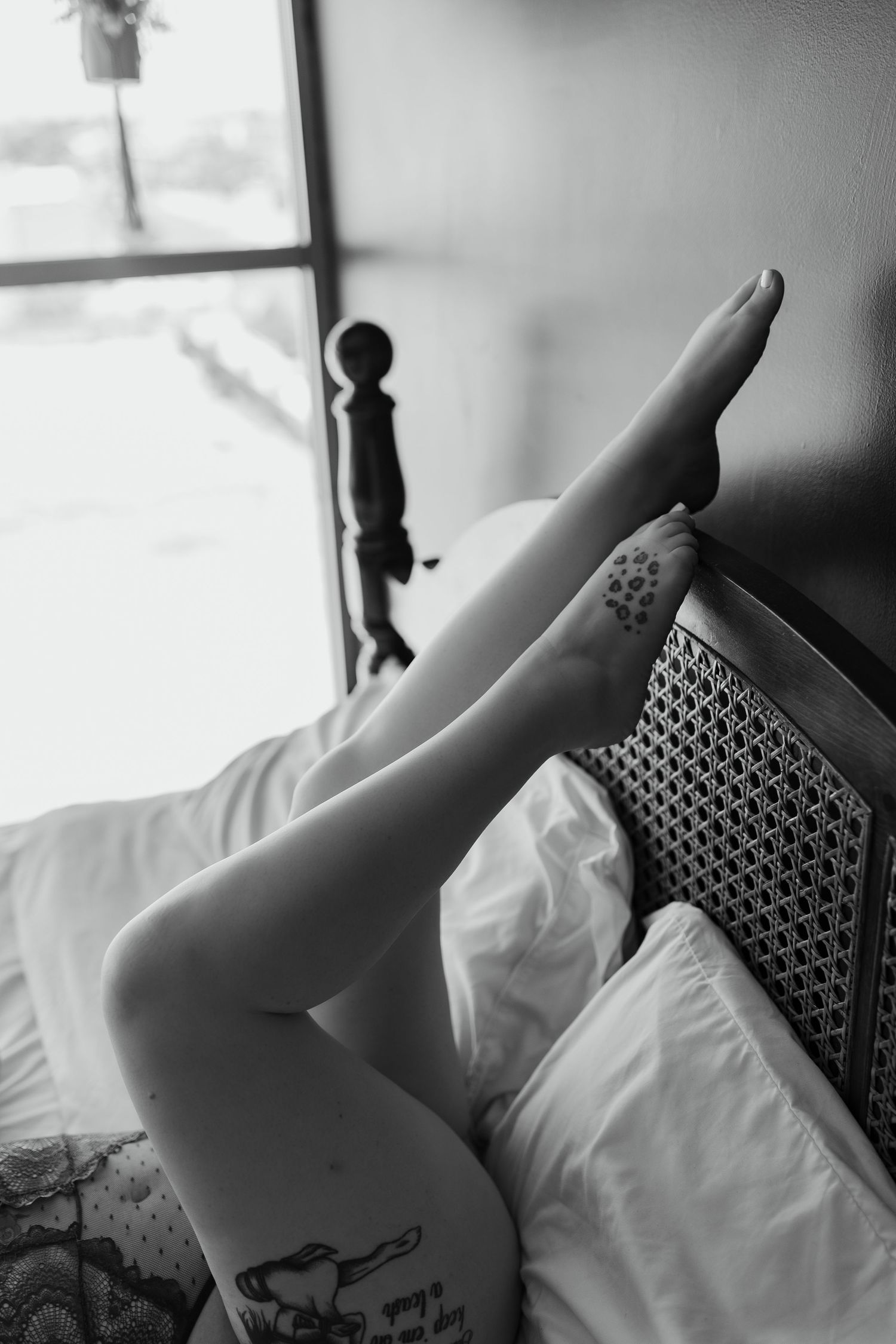 persons legs and feet propped in a headboard sensually posed