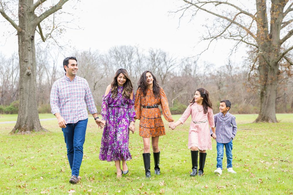 A group walking together through a park on an autumn day wearing coordinated casual outfits.