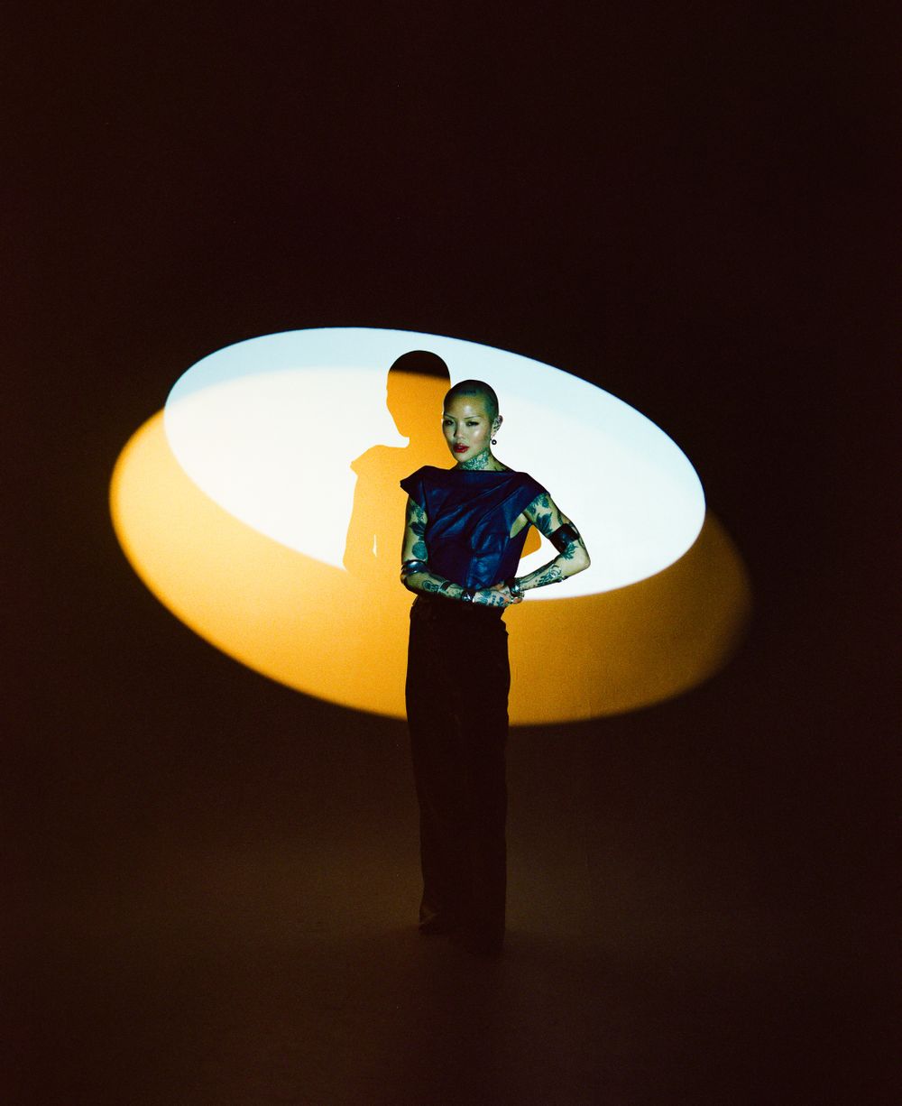 Artistic fashion portrait with oval lighting and dramatic shadow effect.