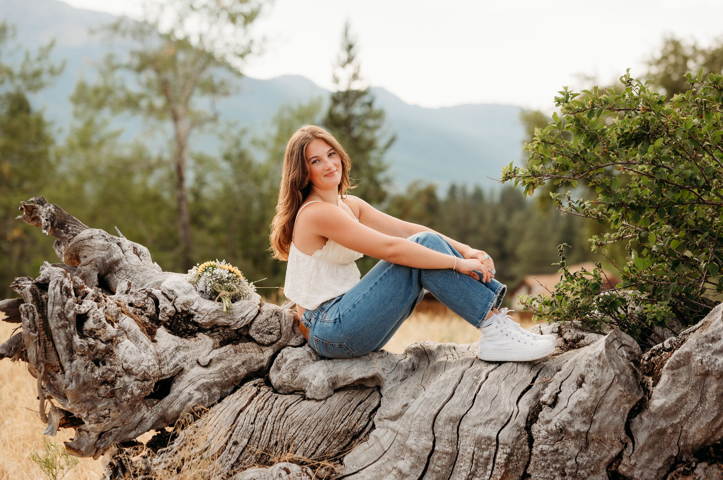 A candid outdoor portrait shot on a rocky outcrop with mountains in the background. Wallowa Lake, Joseph, Oregon