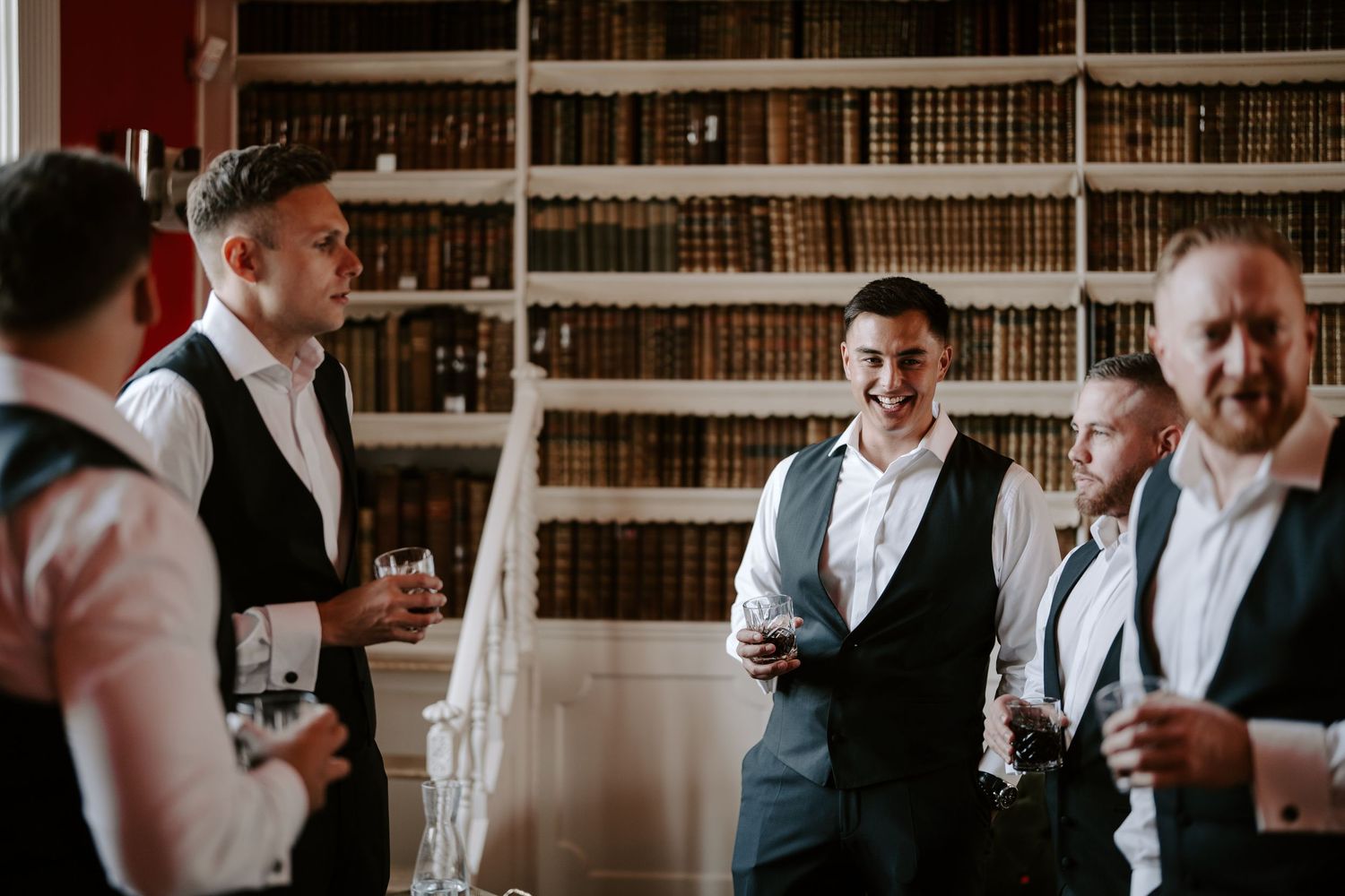 groomsmen having drinks of whiskey in the library at Iscoyd park