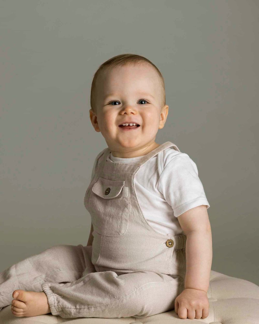 1-åring sittende på en pledd i fotostudio hos barnefotograf i Lyngdal