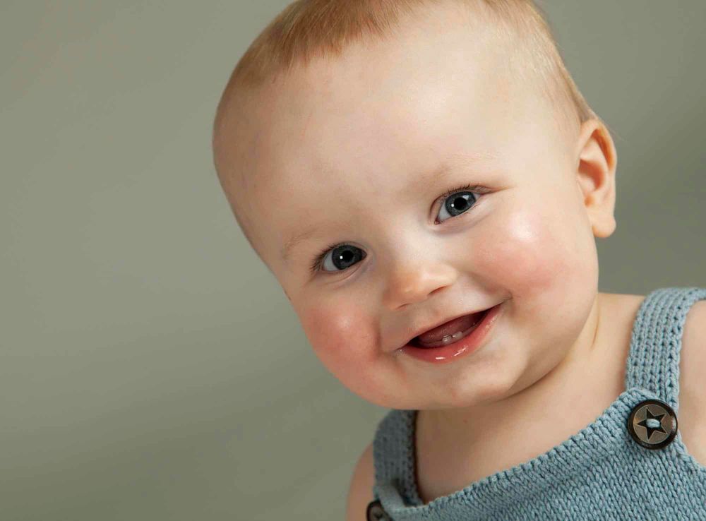Nærbilde av smilende gutt hos barenfotograf i Mandal