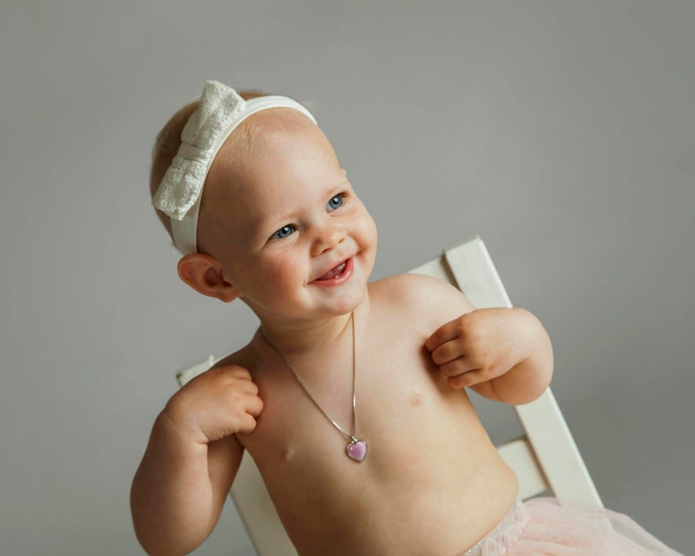 1-årsfoto av jetne med hårpynt sittende på krakk på barnefotografering i fotostudio i Mandal