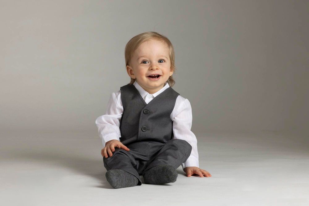 1-åring i hos fotograf i Farsund sitten på gulvet i dress på barnefotografering