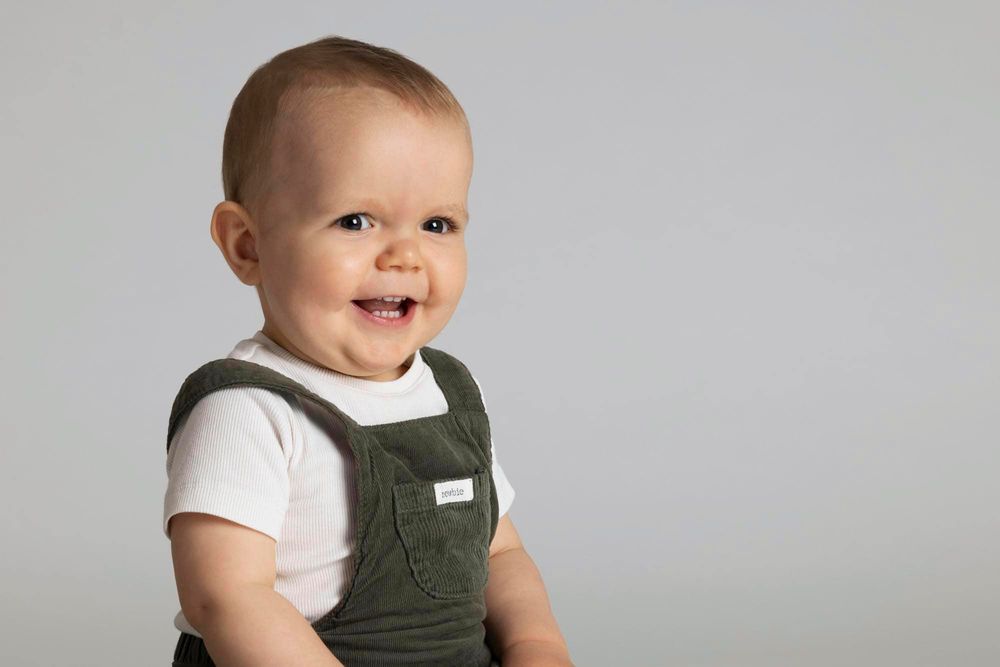 1-årig gutt sitter og smiler på barnefotografering i Flekkefjord