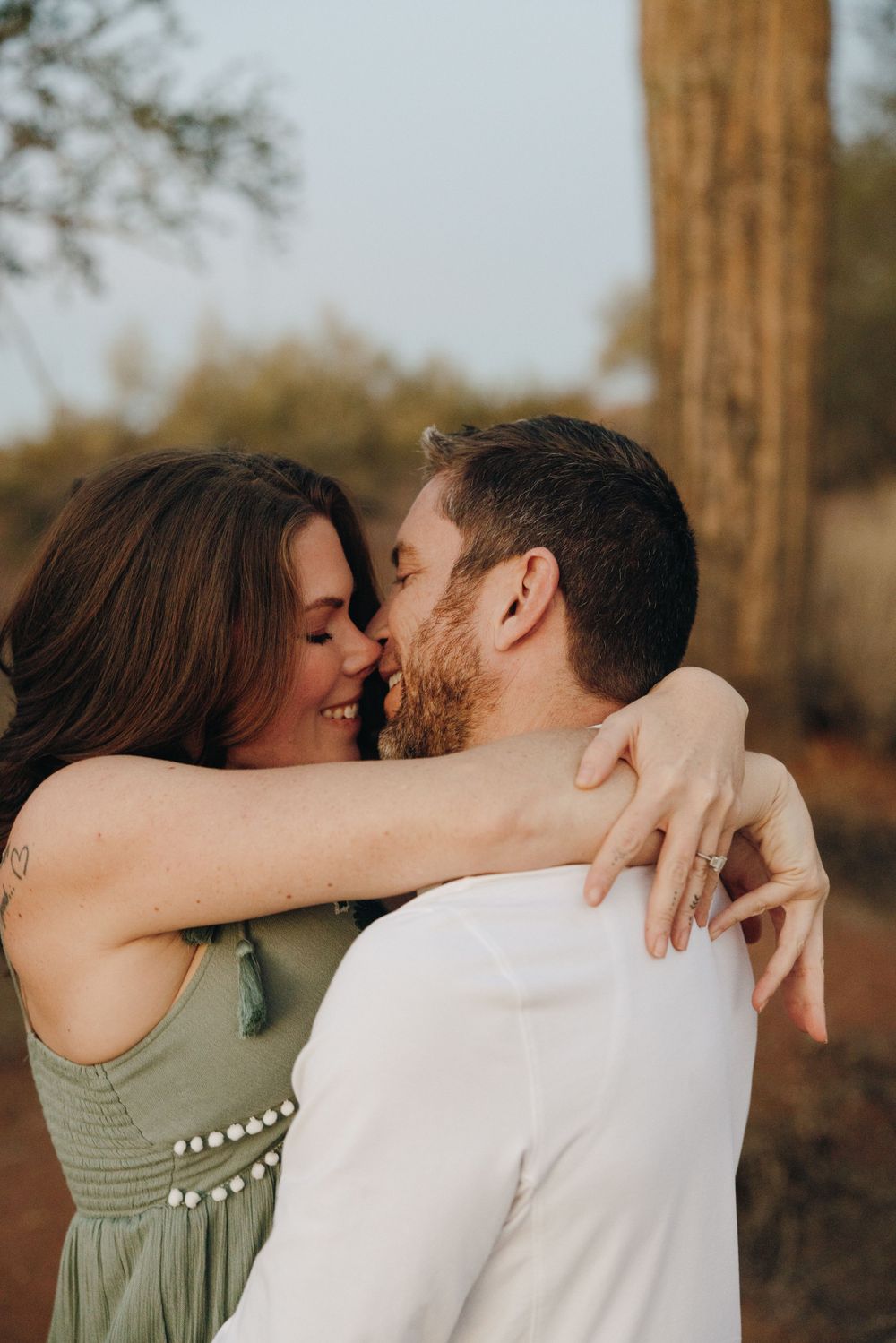 A romantic couple embraces in a series of intimate photos captured outdoors during golden hour lighting near the Salt River.