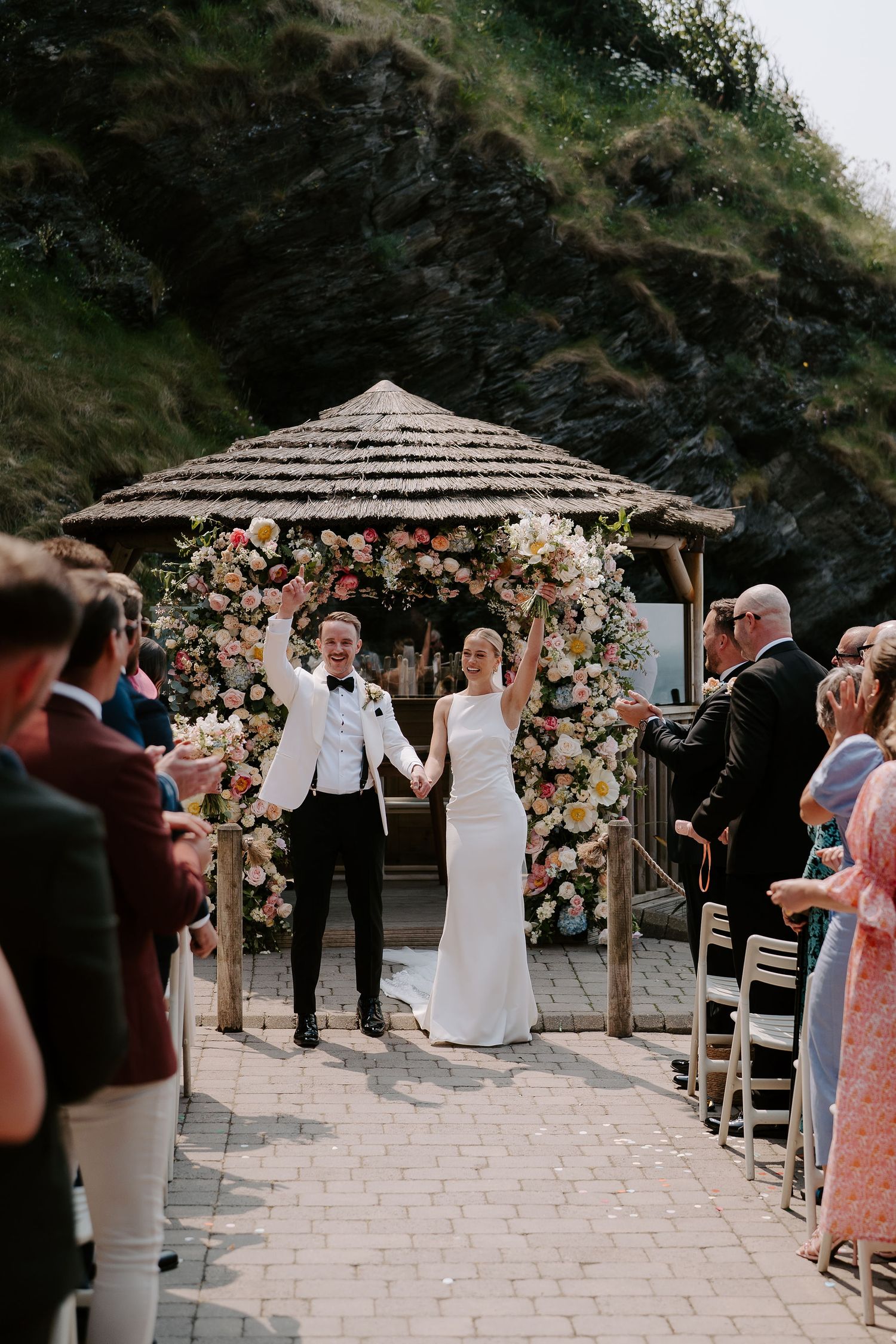 Bride and groom walking down aisle as husband and wife at tunnels beach wedding venue in north Devon