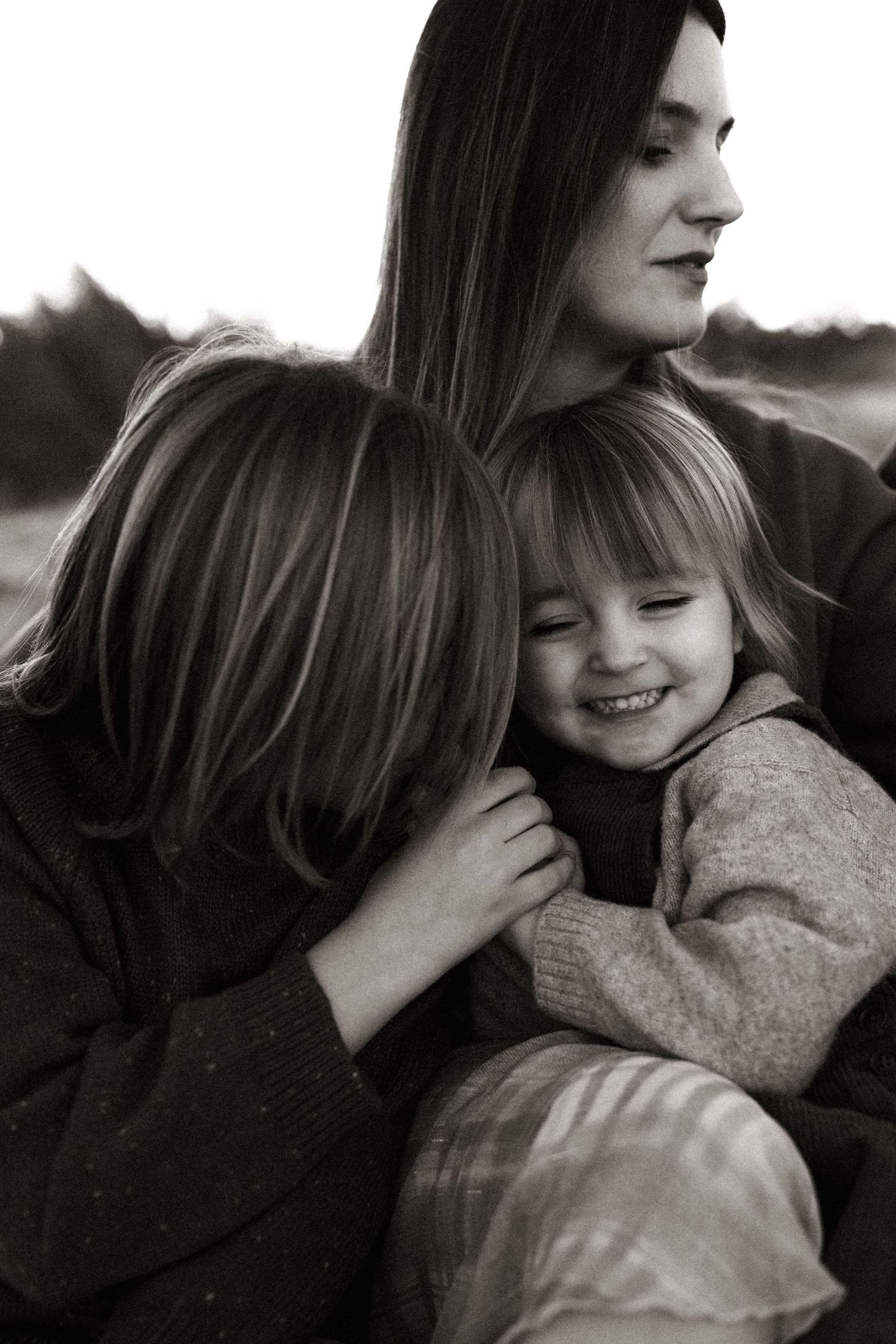 A tender black and white moment of family affection and laughter captured in natural light, with a photographer Javea,and photographer Denia
