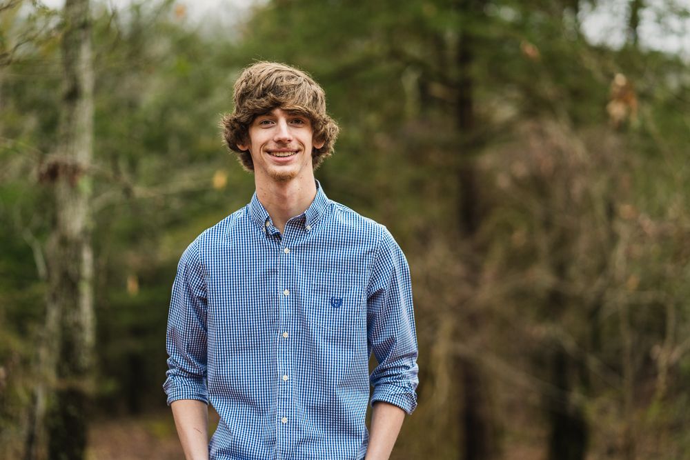 Jefferson County TN high school senior boy posing in the woods by Douglas Lake in Dandridge TN by senior portrait photographer