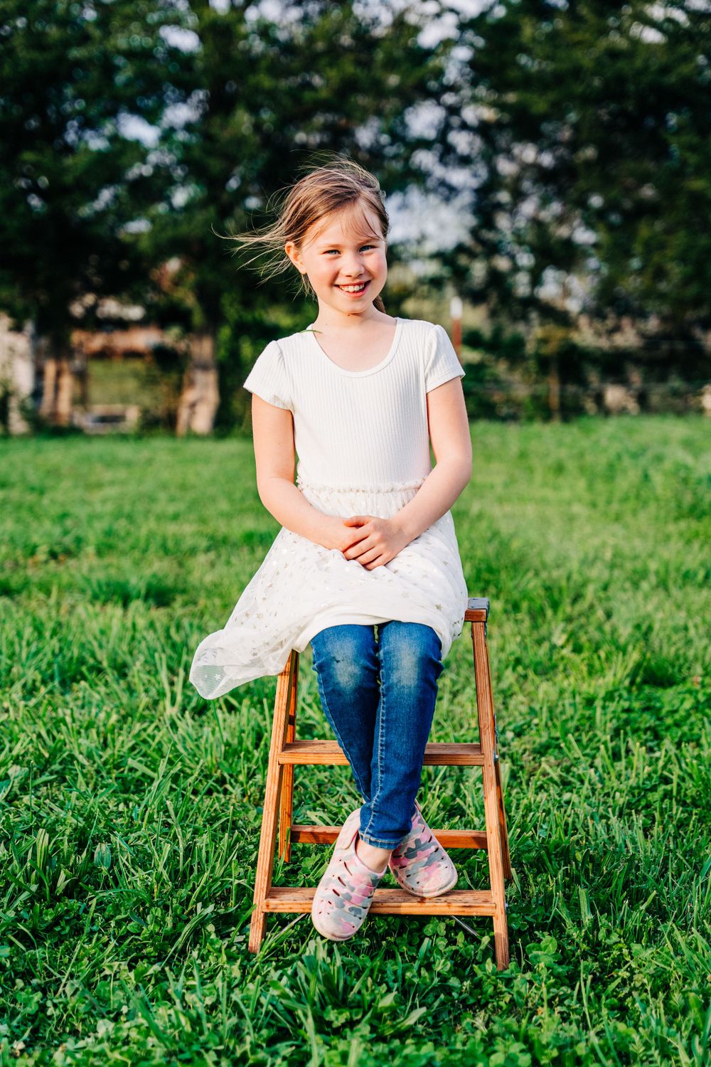Photo of a girl sitting on a ladder  on a farm by East Tennessee lifestyle and family portrait photographer.