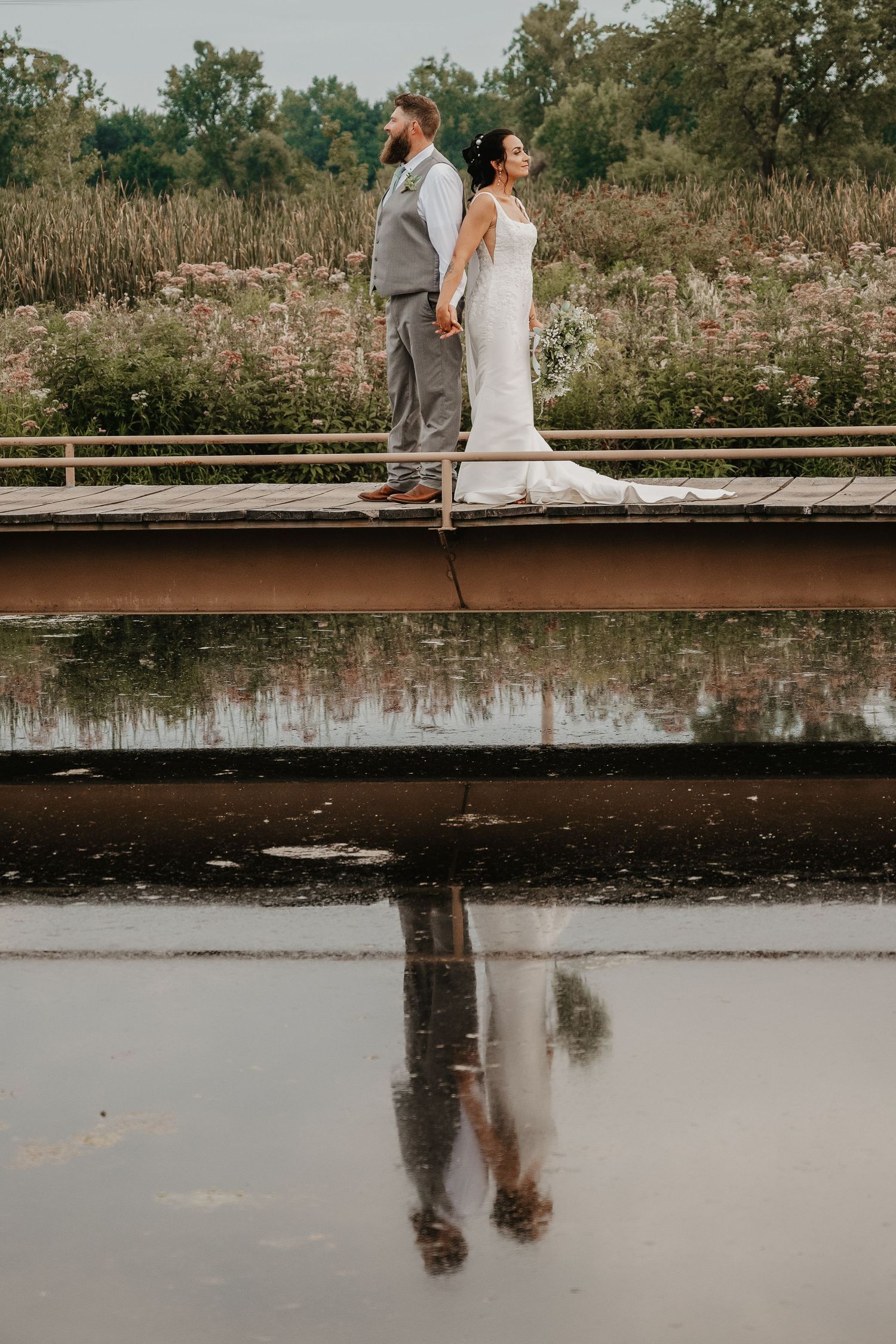 bride and groom portrait on a bridge with reflection in water