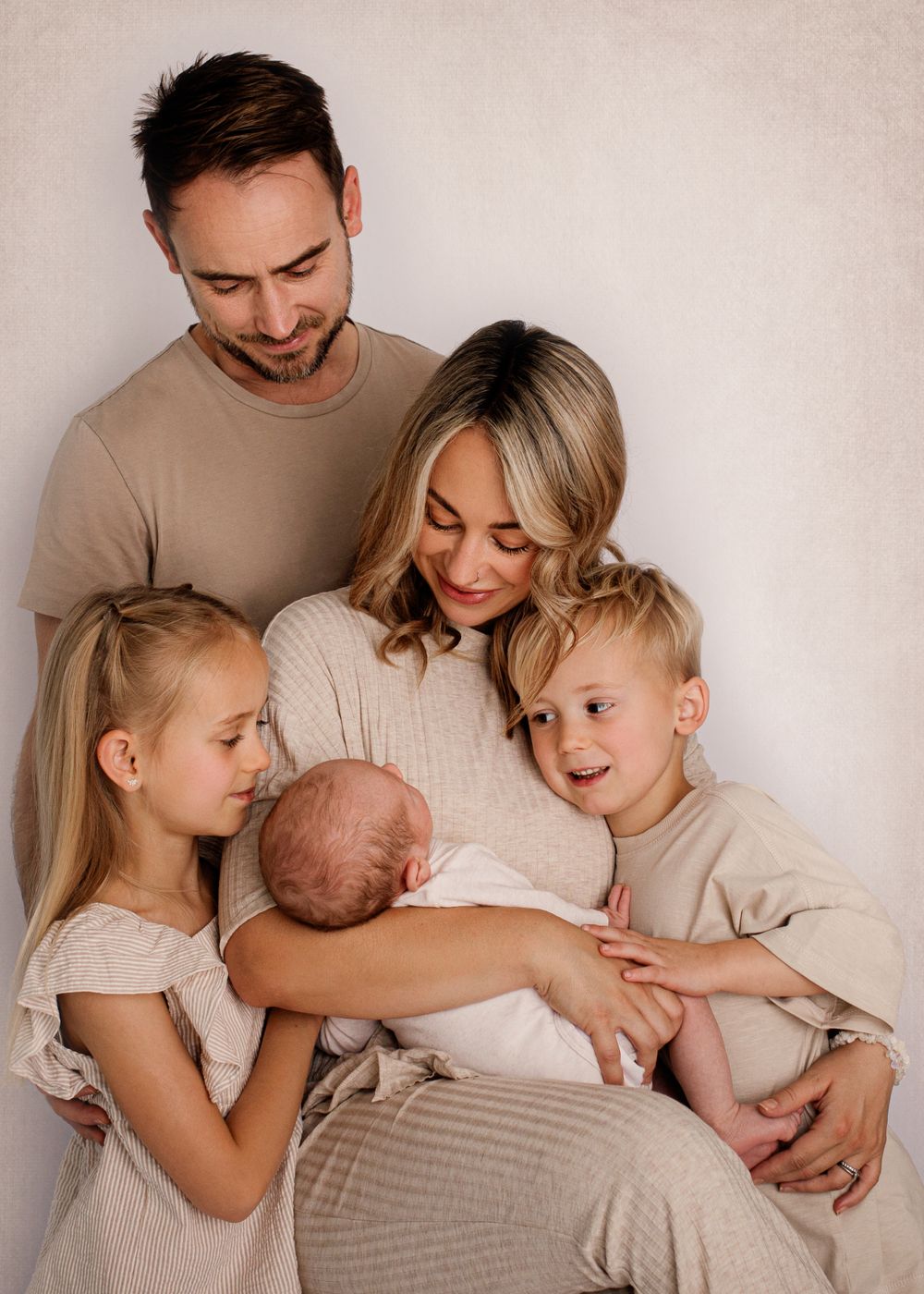 An intimate family portrait in neutral tones showing tender moments together.